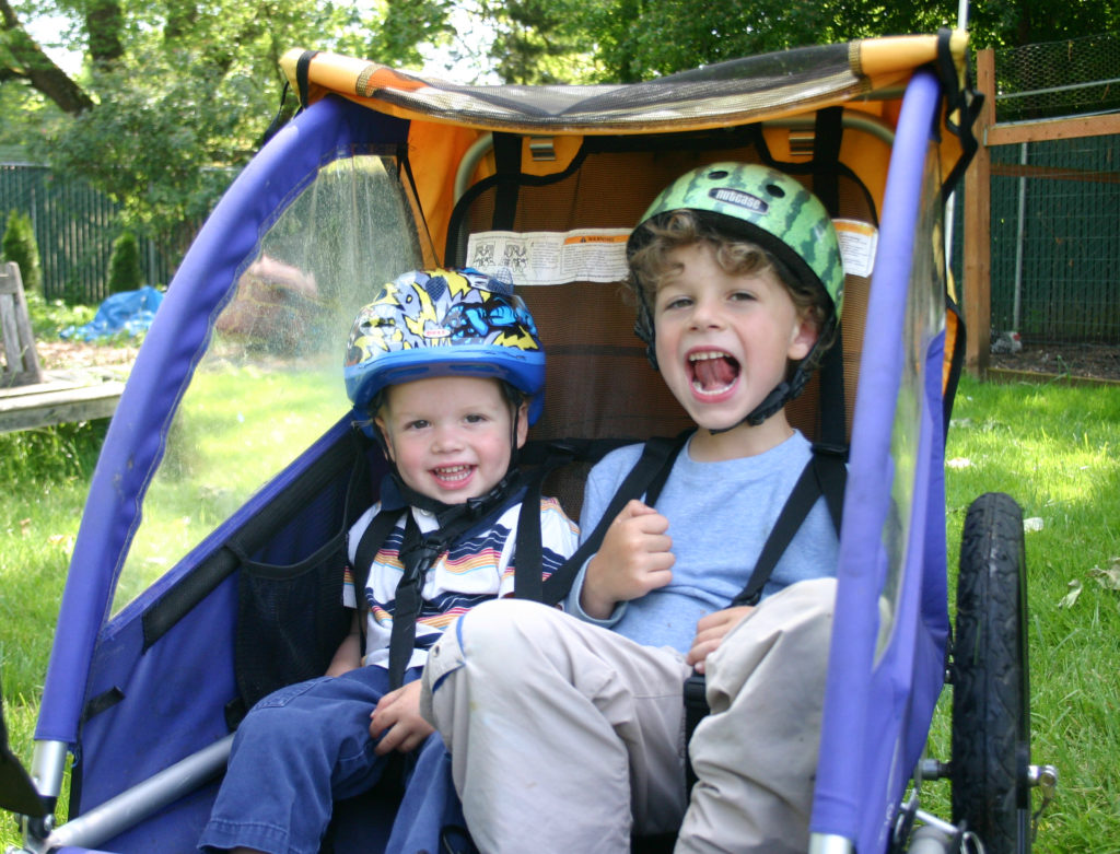 two boys in a bike trailer